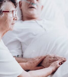 Mains accompagnant un patient en soins palliatifs